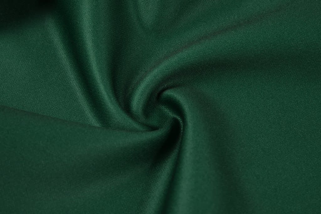 A close-up of green fabric, showcasing a smooth texture with a slight sheen and a swirl pattern.