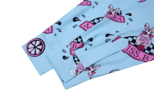 A blue shirt with a playful print featuring pink bunnies, checkers, and circular designs. It has a buttoned cuff detail.
