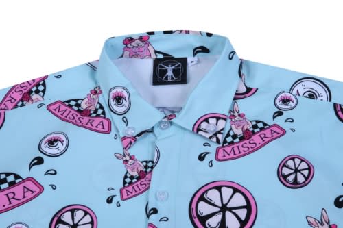 A light blue shirt featuring a playful pattern with cartoon rabbits, lemons, and various badges, including a logo.