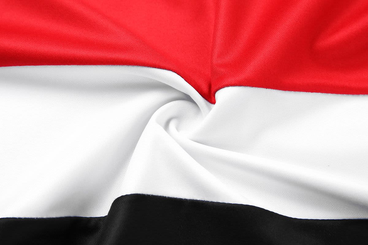 A fabric singlet featuring red, white, and black horizontal stripes, with a smooth texture and a twisted design.