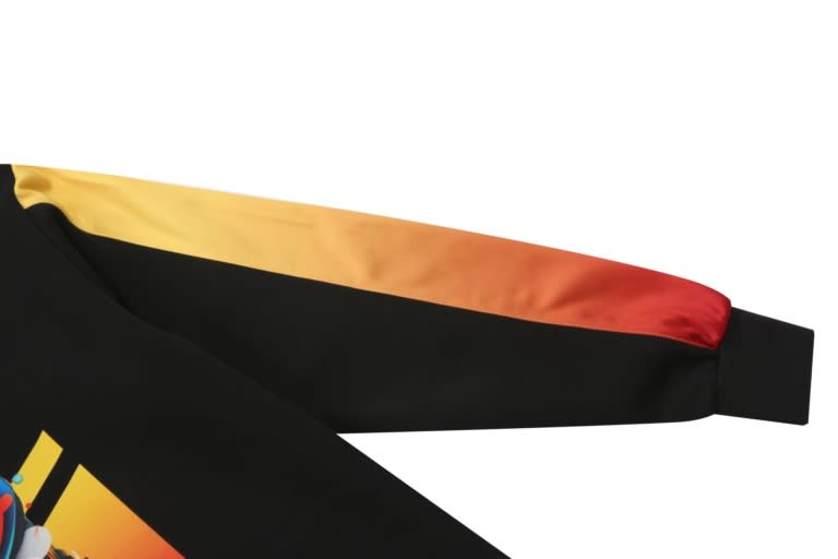 A black hoodie with a gradient yellow to red sleeve. It features a decorative design and includes a logo.