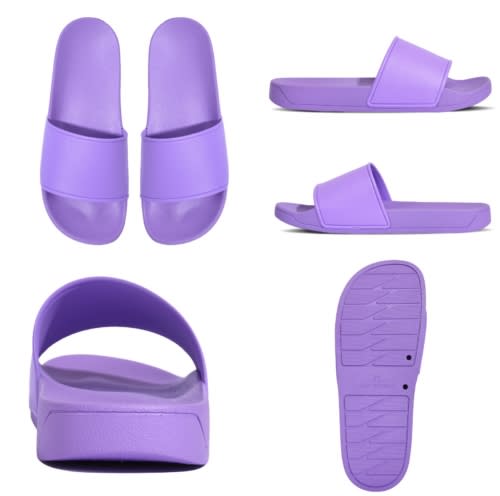 Purple slippers featuring a simple design, with a smooth finish and a durable sole. The product has a logo on it.