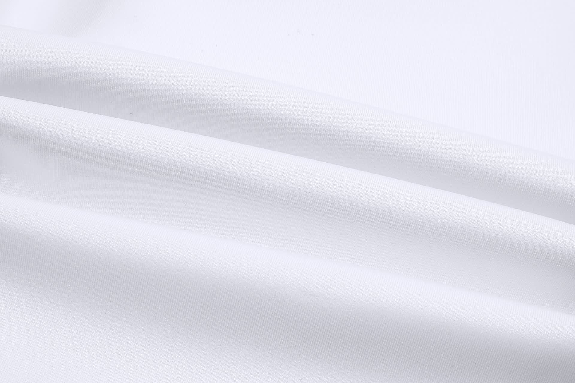 A close-up of smooth, white fabric, showcasing the texture and quality of the material used in cricket uniform pants.
