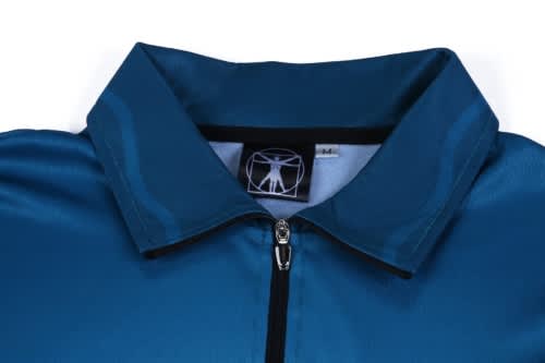 A close-up of a teal sports jersey featuring a zip collar and a logo on the neckline.