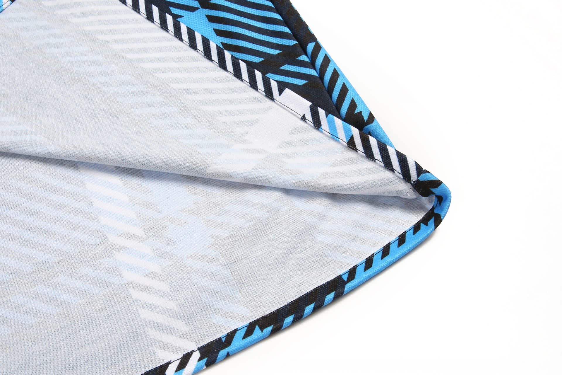 A flannel shirt featuring a blue and black patterned design with geometric shapes. The fabric is folded showing its interior.