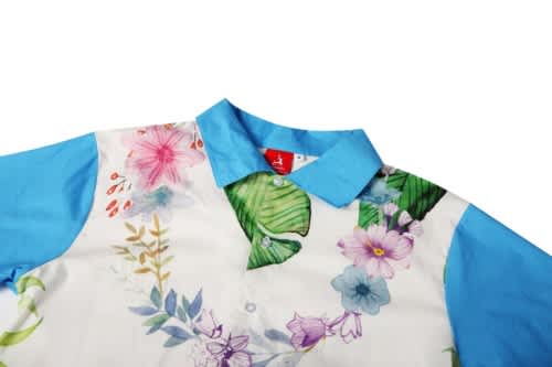 A floral-patterned shirt in white and blue, featuring a blue collar and vibrant botanical designs.