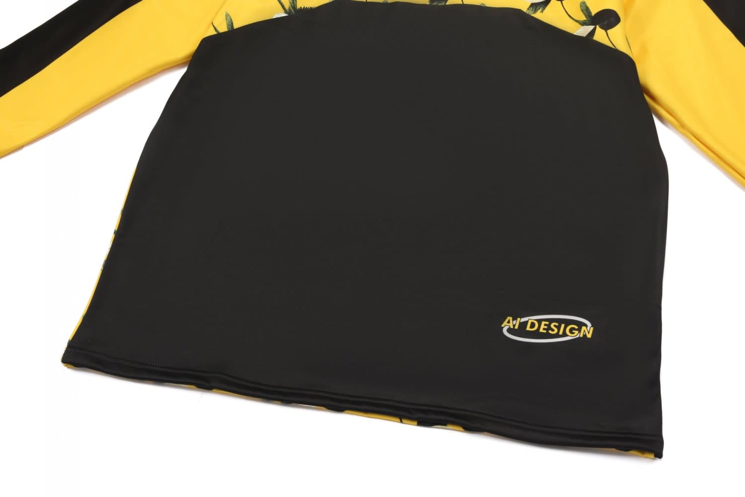 A black and yellow pullover jumper with floral designs and a logo on the bottom right.