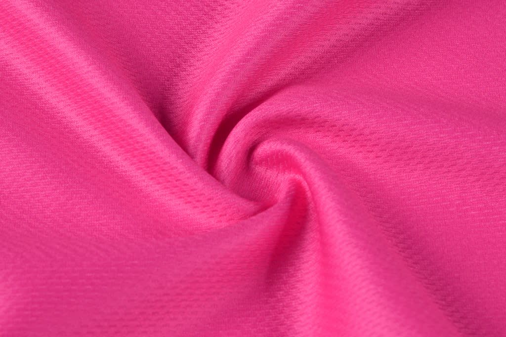 A close-up of pink fabric with a smooth, textured surface, showcasing a swirling pattern.