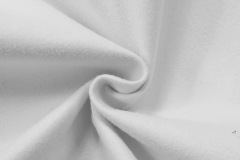 A white fabric with a soft, smooth texture, showing folds and twists.