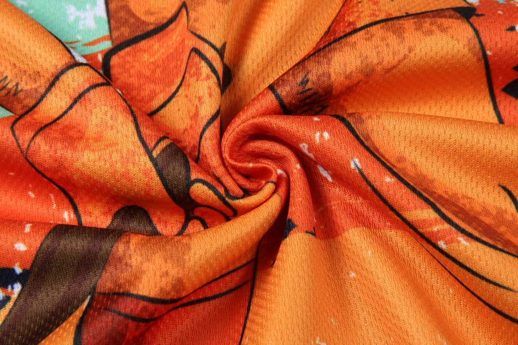 A vibrant fabric featuring an orange and brown design, with a swirling pattern and texture.