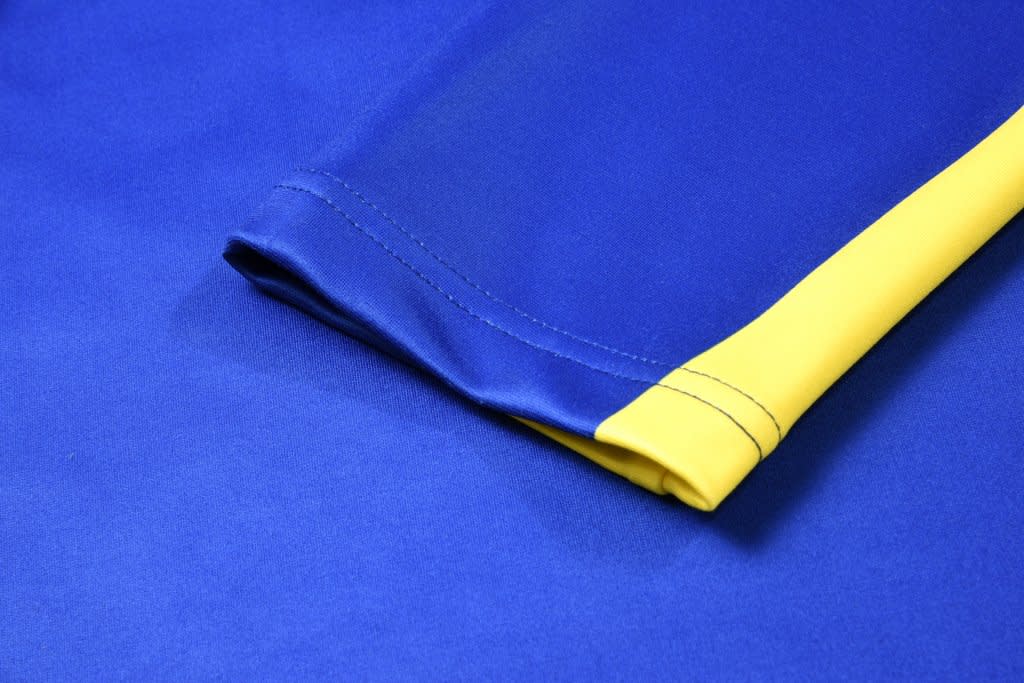 A blue and yellow sublimated pullover featuring smooth fabric and visible stitching details. It has a logo on it.