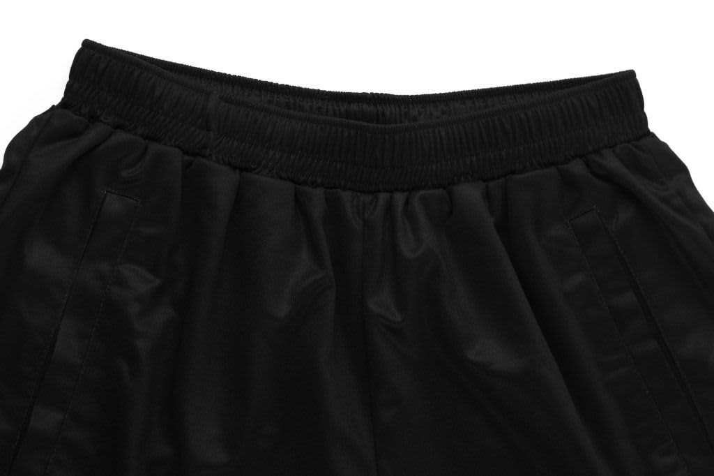 Black sublimation lawn bowls pants featuring an elastic waistband and side pockets. The material has a glossy finish.