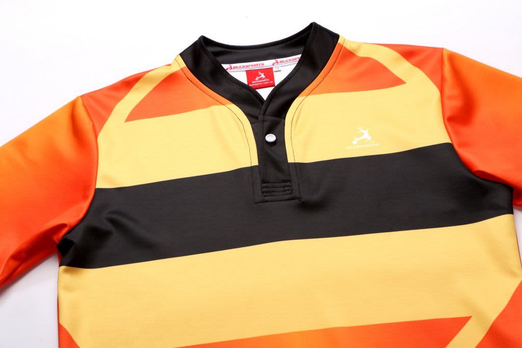 A rugby tee in vibrant orange, yellow, and black stripes with a collar and a logo on the chest.