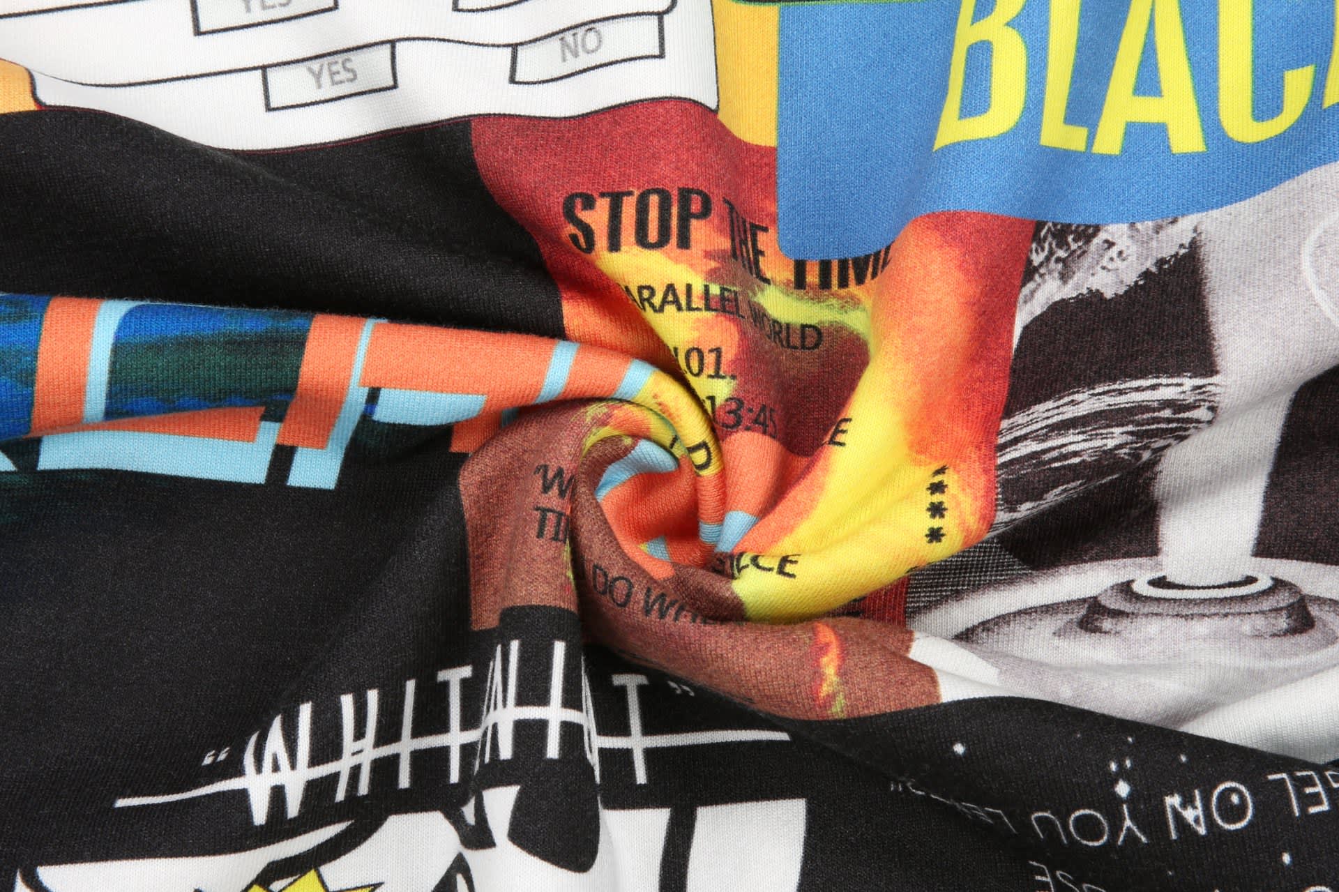 A patterned fabric featuring vibrant colours and various designs, showcasing graphics and text elements.