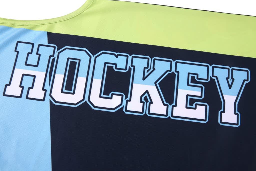 A sport jersey featuring bold letters spelling "HOCKEY" in blue and white on a multicoloured background.