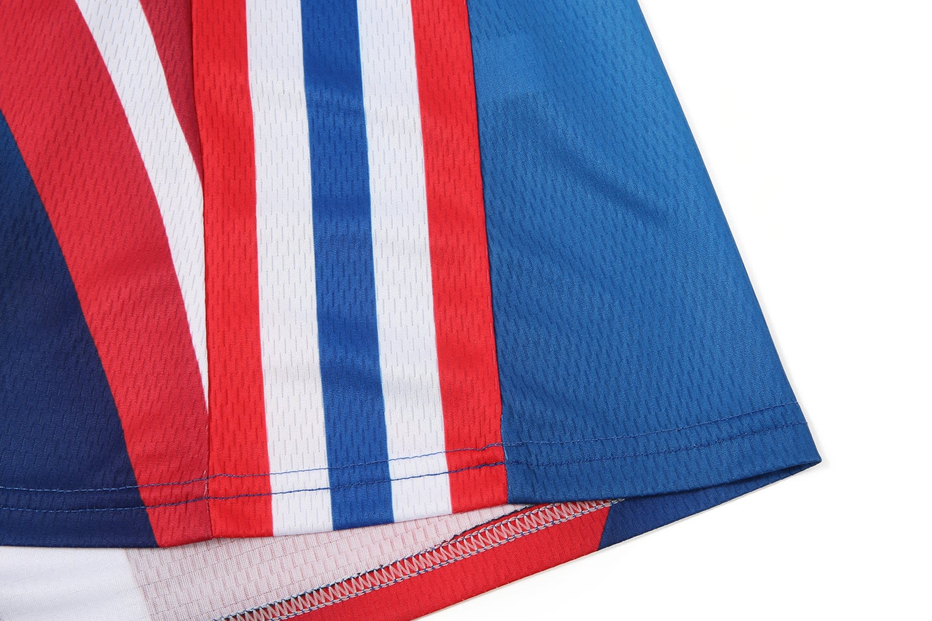 A close-up of a netball dress featuring blue, red, and white stripes, with a logo on the fabric.