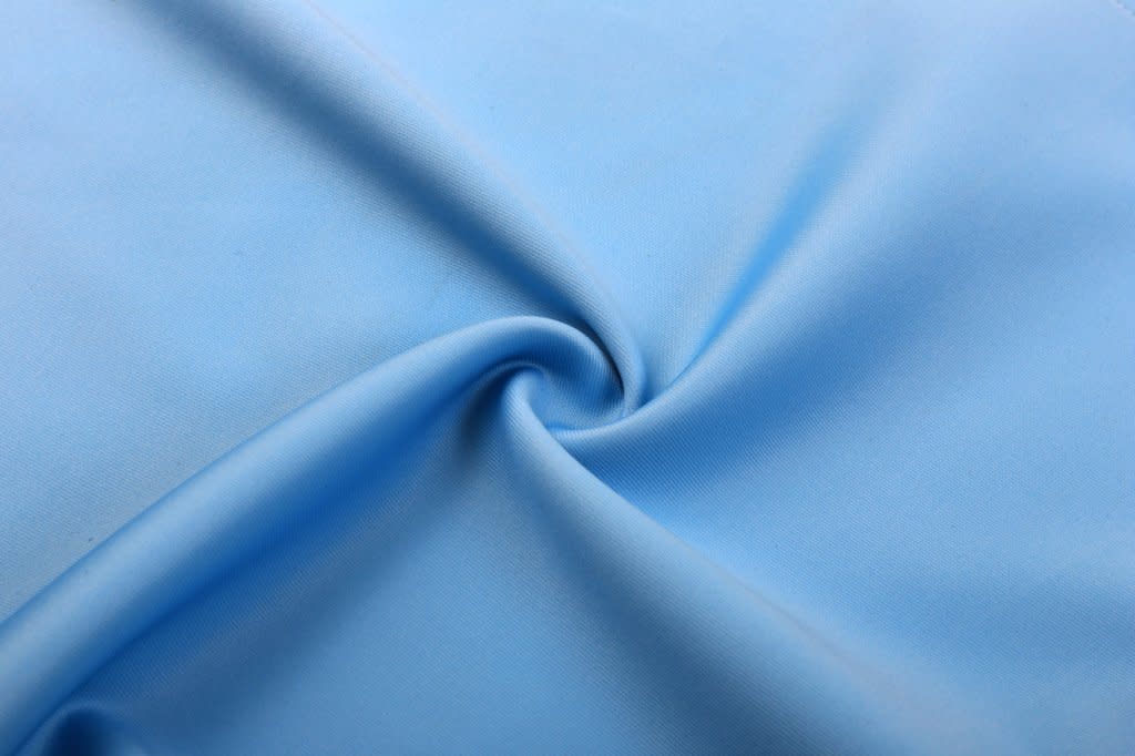 AFL vest made of smooth, light blue fabric, featuring a central swirl pattern. The fabric has a soft texture.