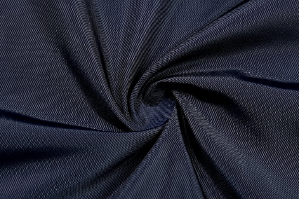 A dark navy fabric with a smooth texture, arranged in a spiral pattern, showcasing its soft feel.