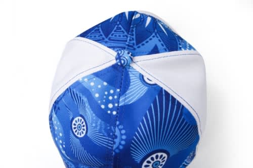 A blue sublimated sport cap featuring intricate patterns and a contrasting white brim, with a logo on it.