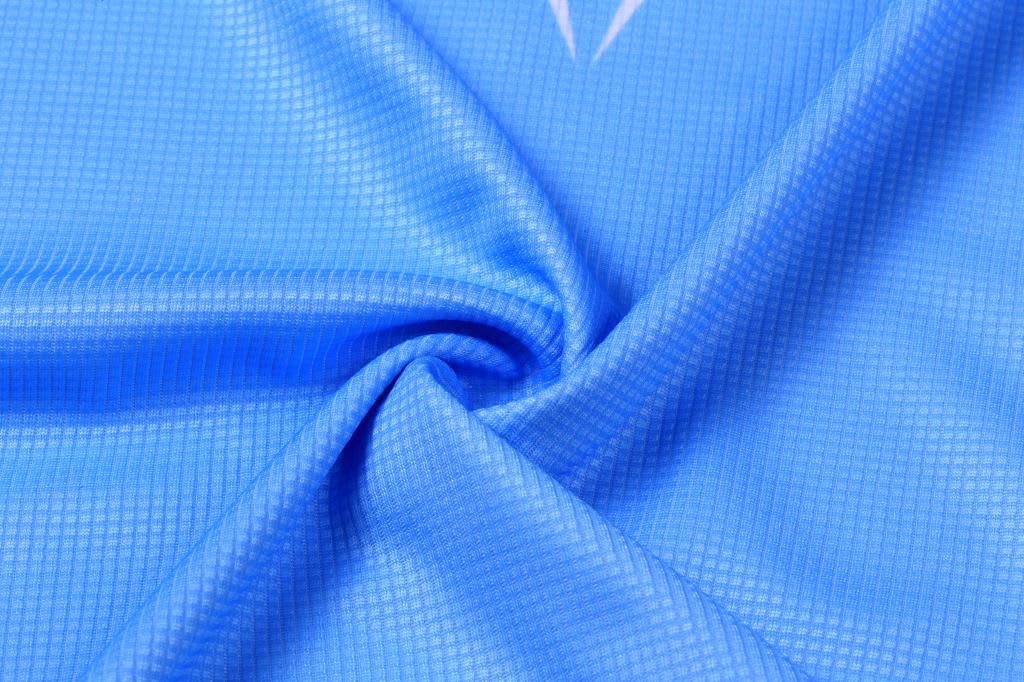 A blue mini waffle fabric with a textured pattern, featuring a subtle sheen and a smooth finish.