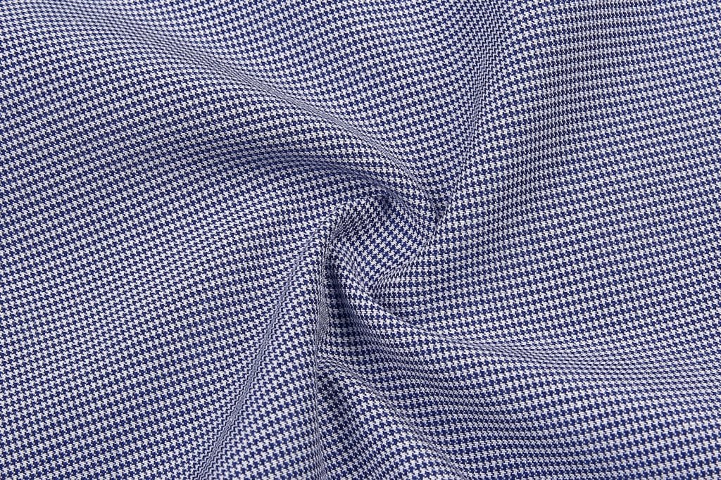 A close-up of a fabric featuring a blue and white check pattern, with a smooth texture and subtle sheen.