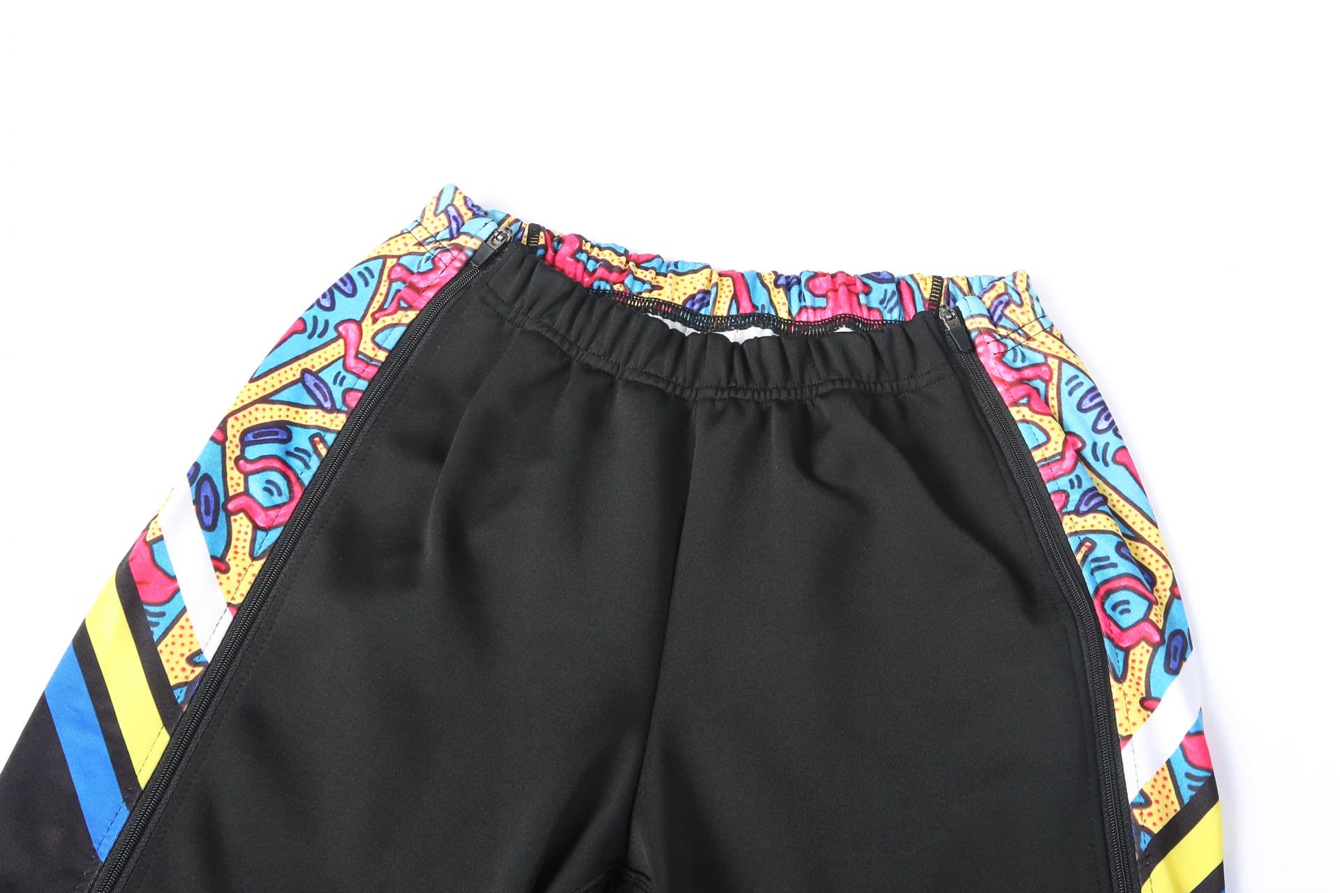 WARM UP PANTS in black with vibrant, multicoloured patterned waistband and side details. Features a logo.