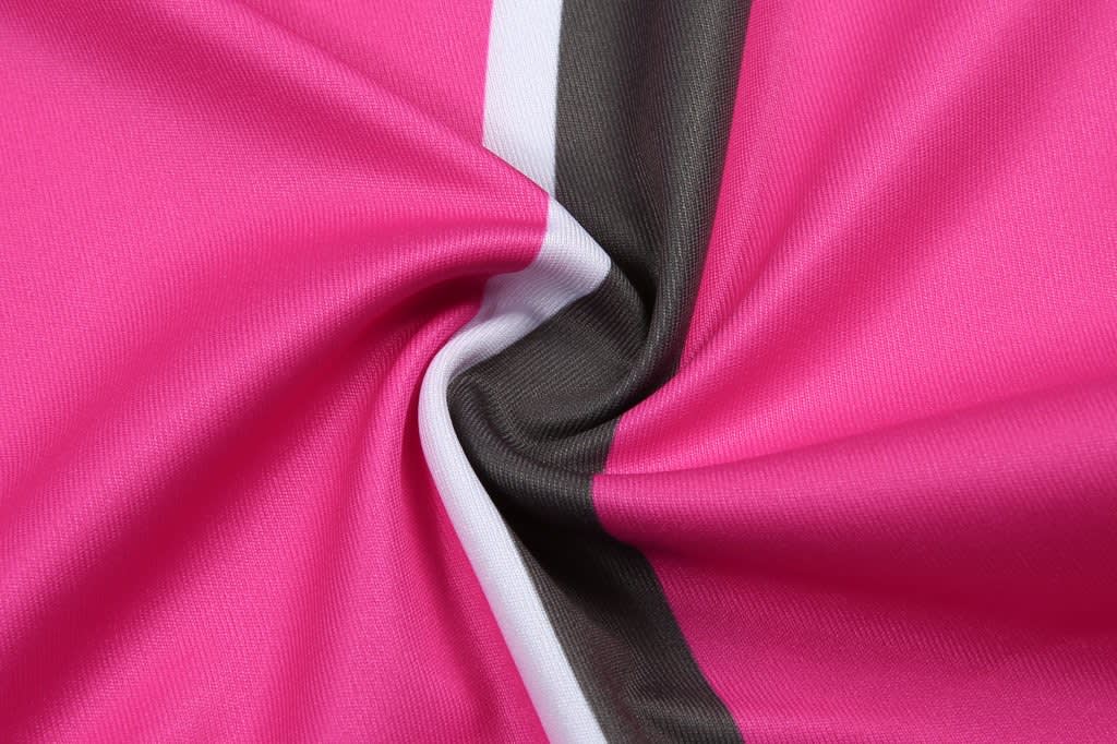 A close-up of a pink and black sublimated fabric, showcasing smooth texture and vibrant colours.