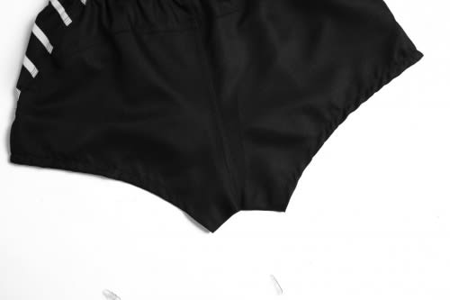 A black AFL player uniform featuring striped detailing on the sides, showcasing a sporty design.