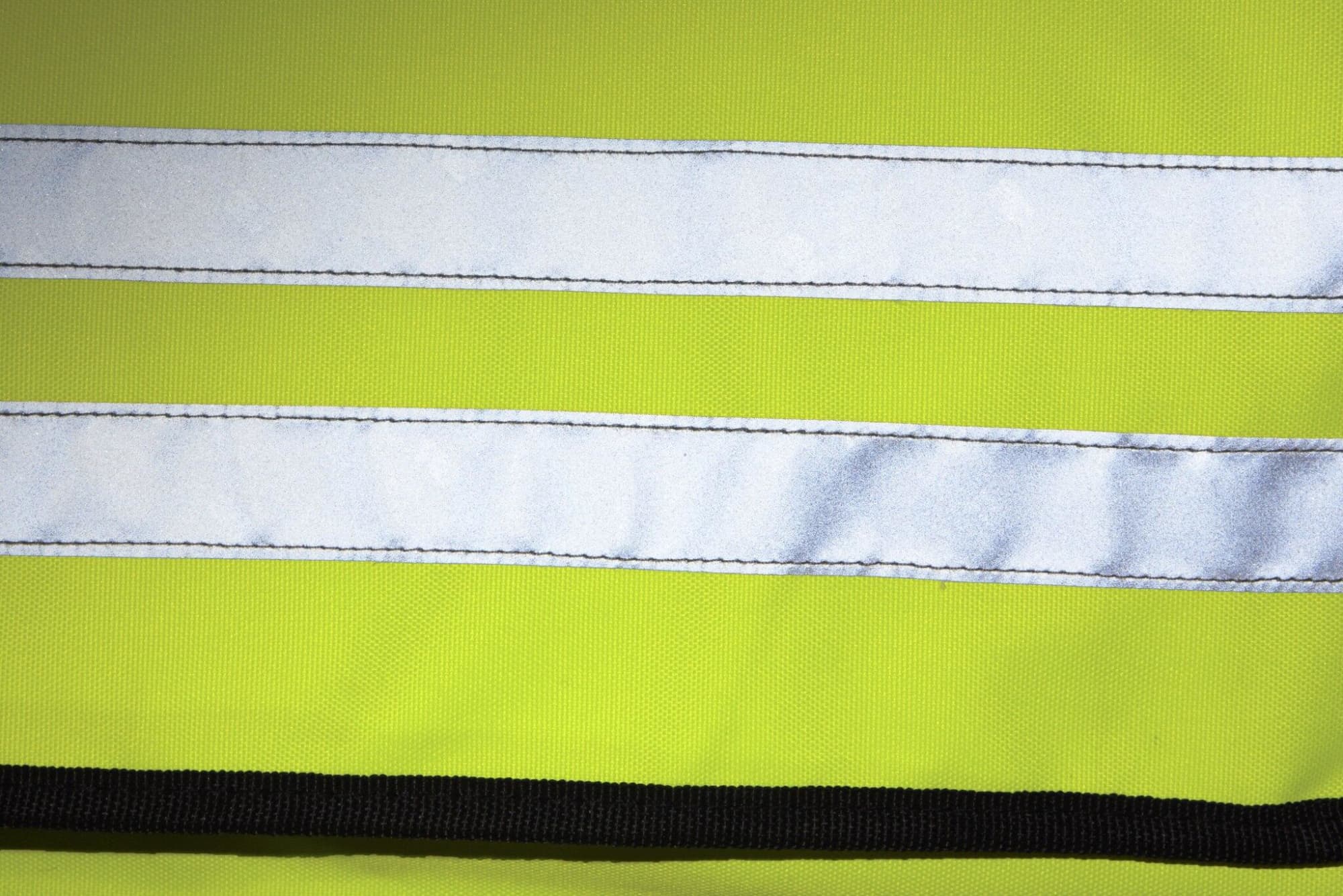 A bright yellow shoulder bag with reflective white stripes and black trim, featuring a logo.