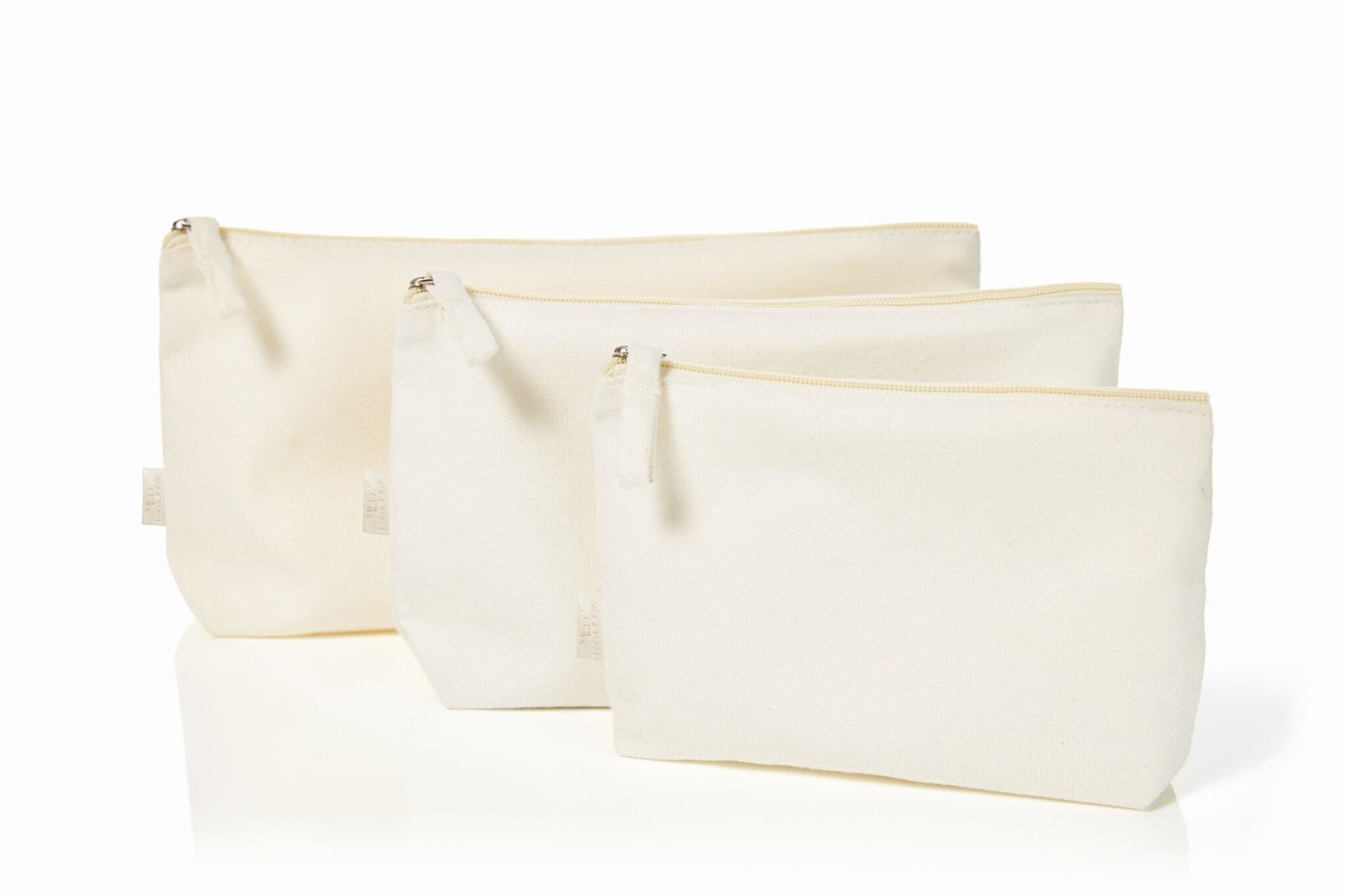 Three off-white organic zipper bags of varying sizes, each with a zip closure and one featuring a logo.