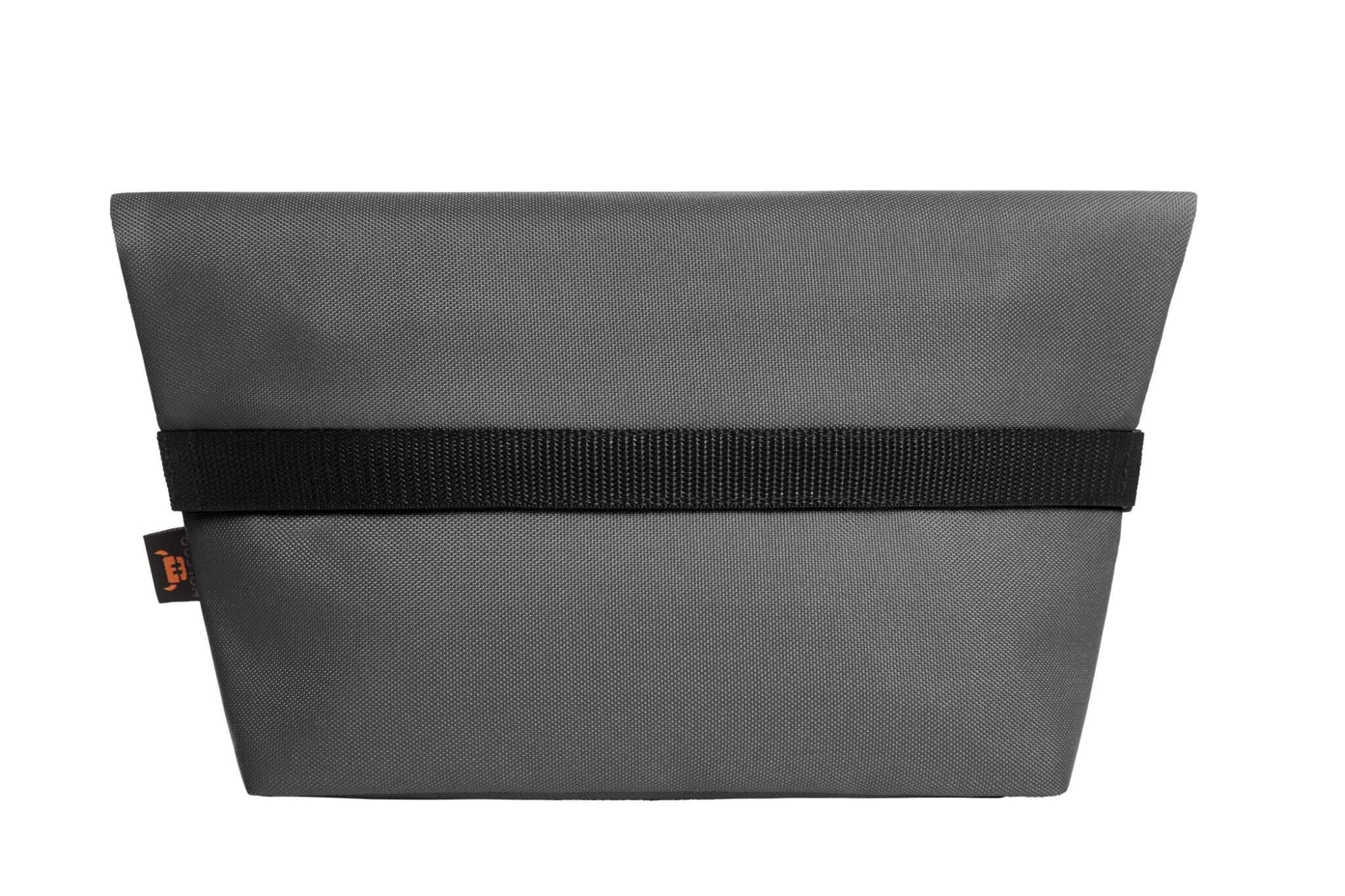 A grey cooler bag with a black strap and a logo, featuring a sleek, minimalistic design.