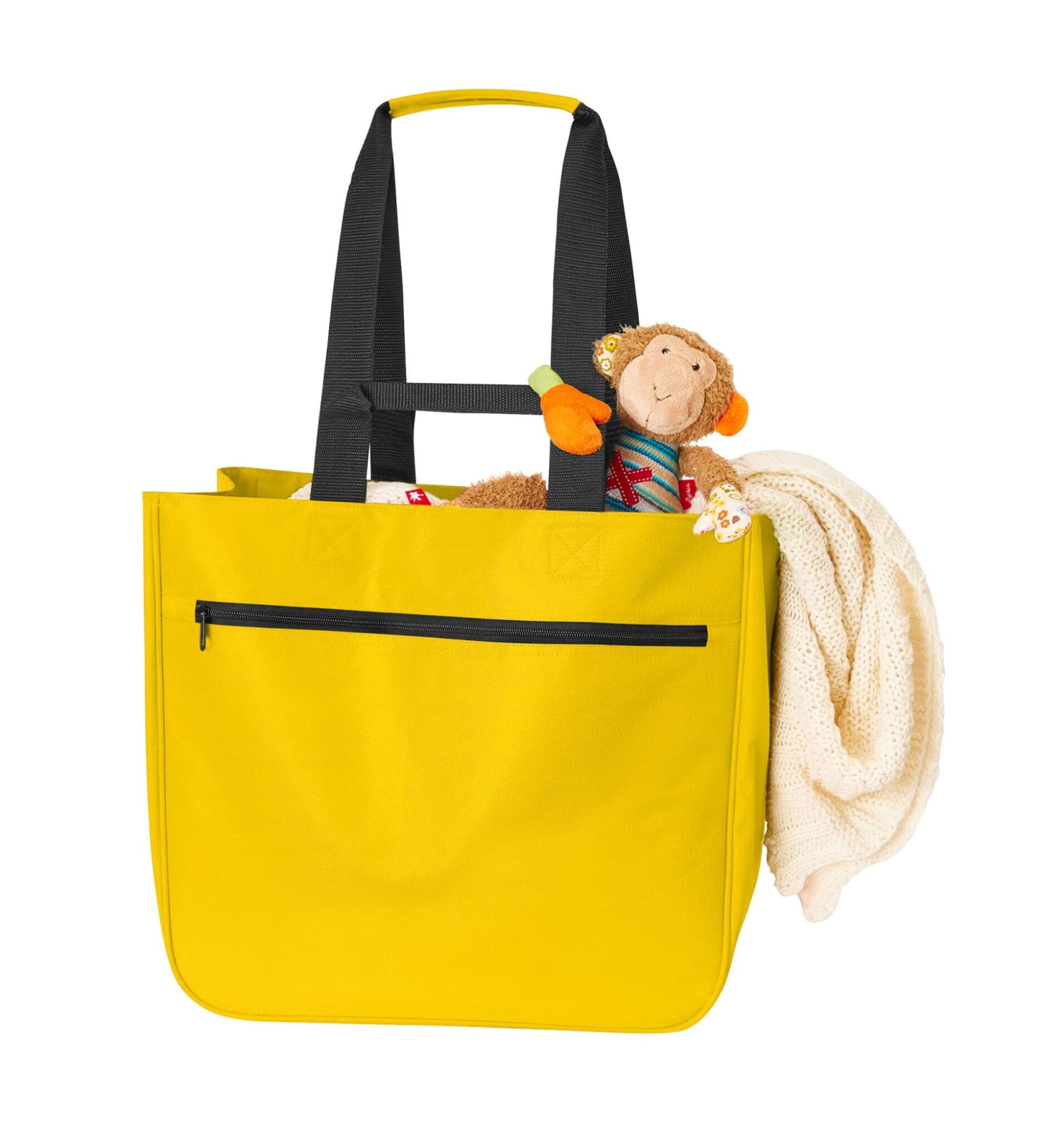 A yellow tote bag with black straps, holding a plush monkey toy and a blanket. The bag features a zippered pocket.