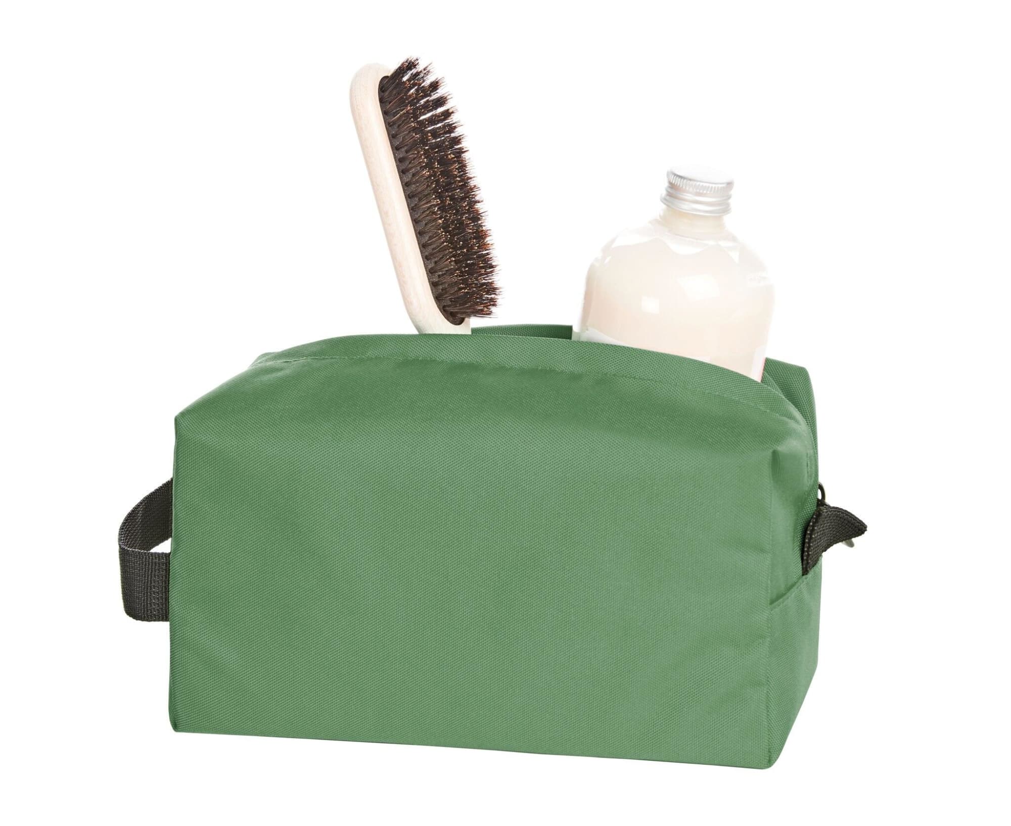 A green toiletry bag containing a brush and a drink bottle. It features a simple design and has a handle.