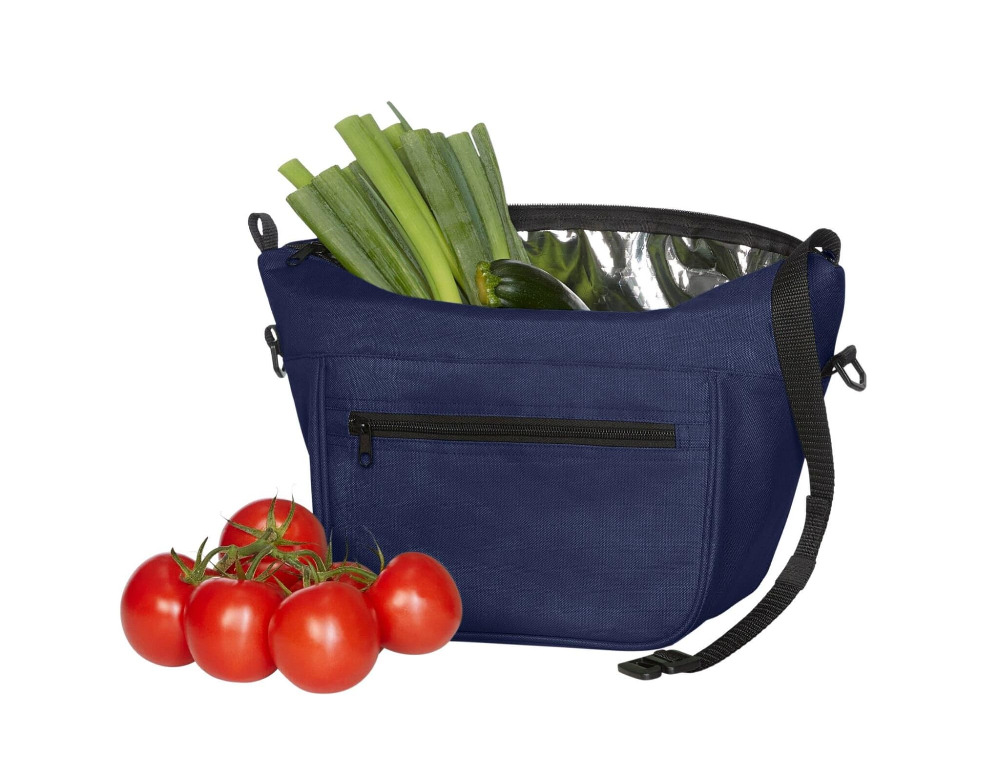 A navy lunch bag with a silver lining, filled with vegetables and a cluster of red tomatoes beside it.