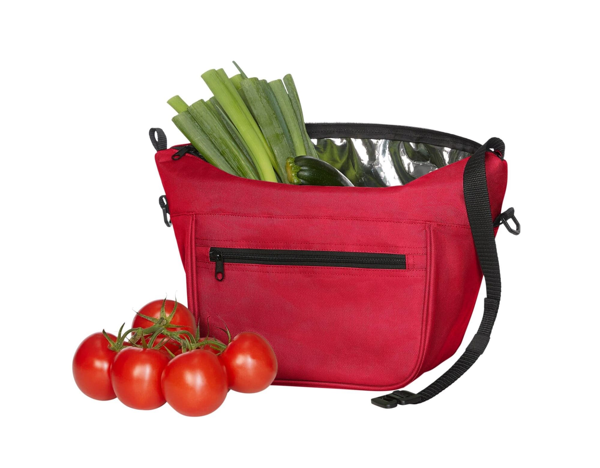 A red lunch bag with a shiny interior, holding green leeks and vegetables, accompanied by a bunch of red tomatoes.