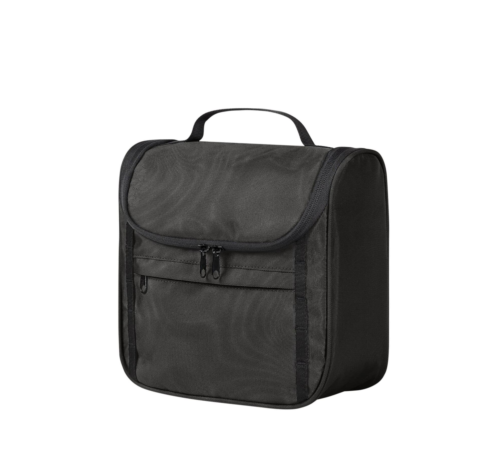 A black toiletry bag features a main compartment with a zippered closure and a front pocket, ideal for organising essentials.