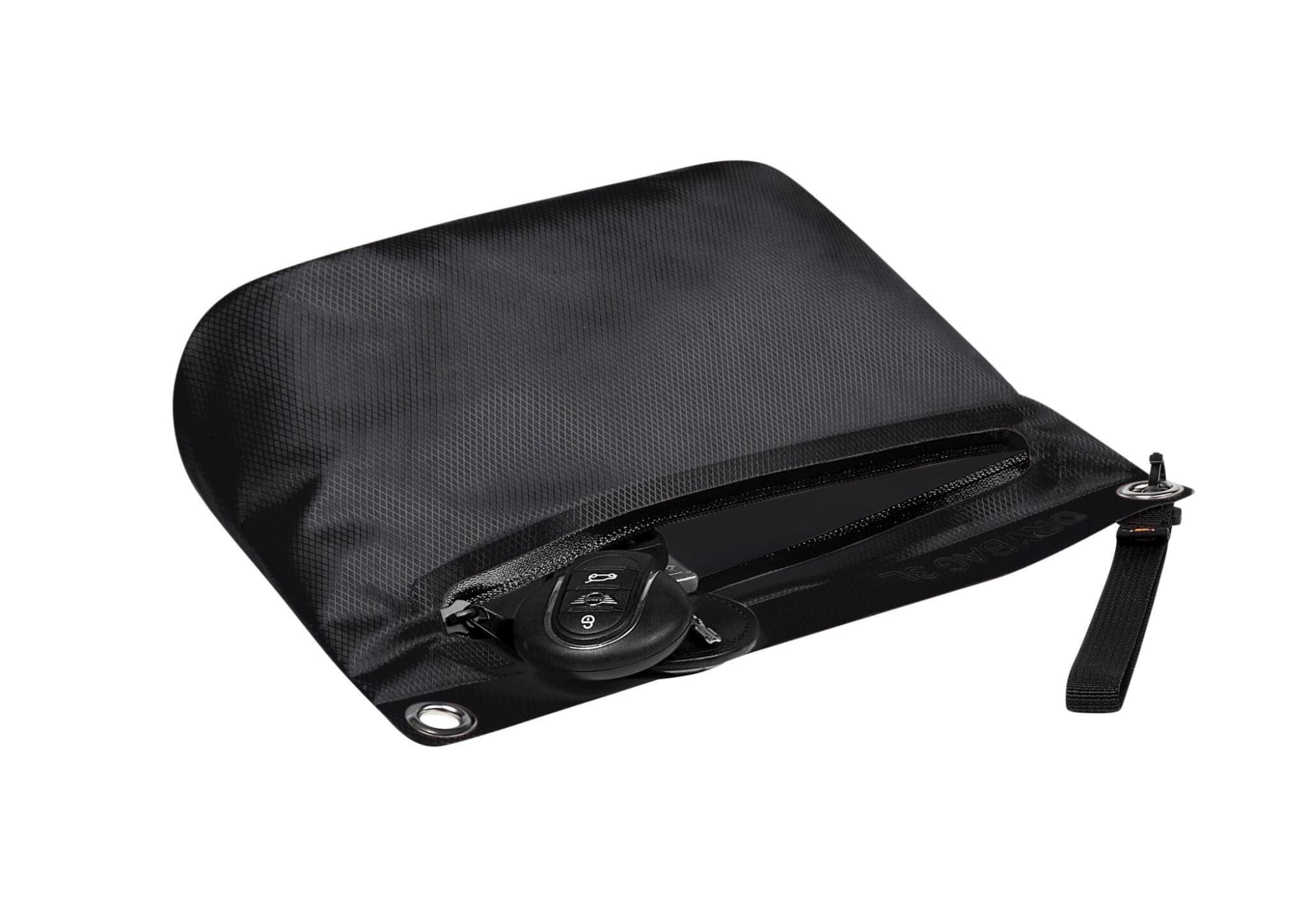 A black dry bag features a zippered closure and a wrist strap, with a set of keys placed inside.