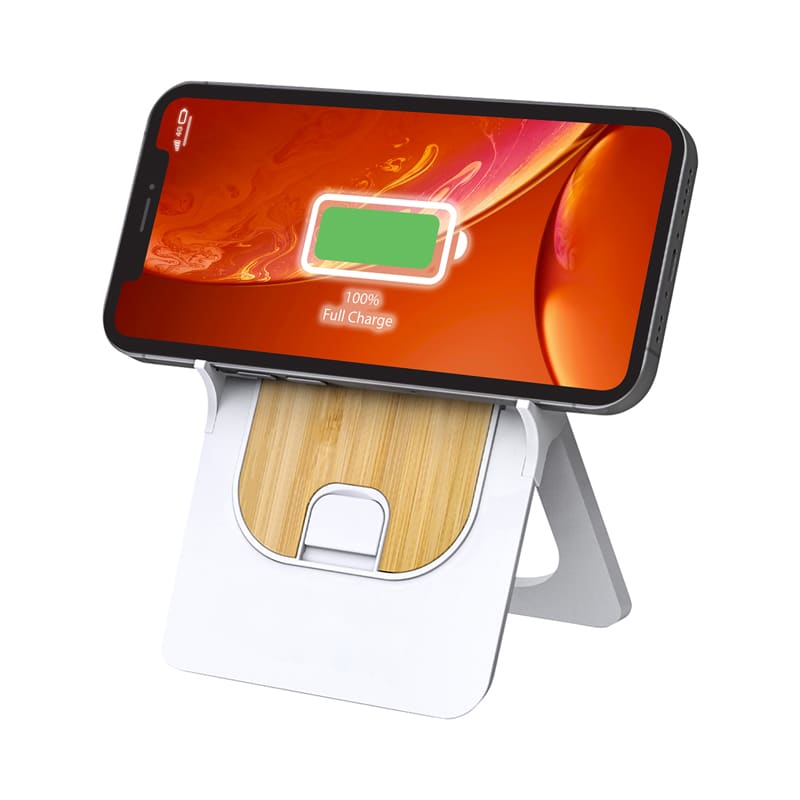 A wireless charging stand in white and bamboo, holding a smartphone displaying a full charge indicator.