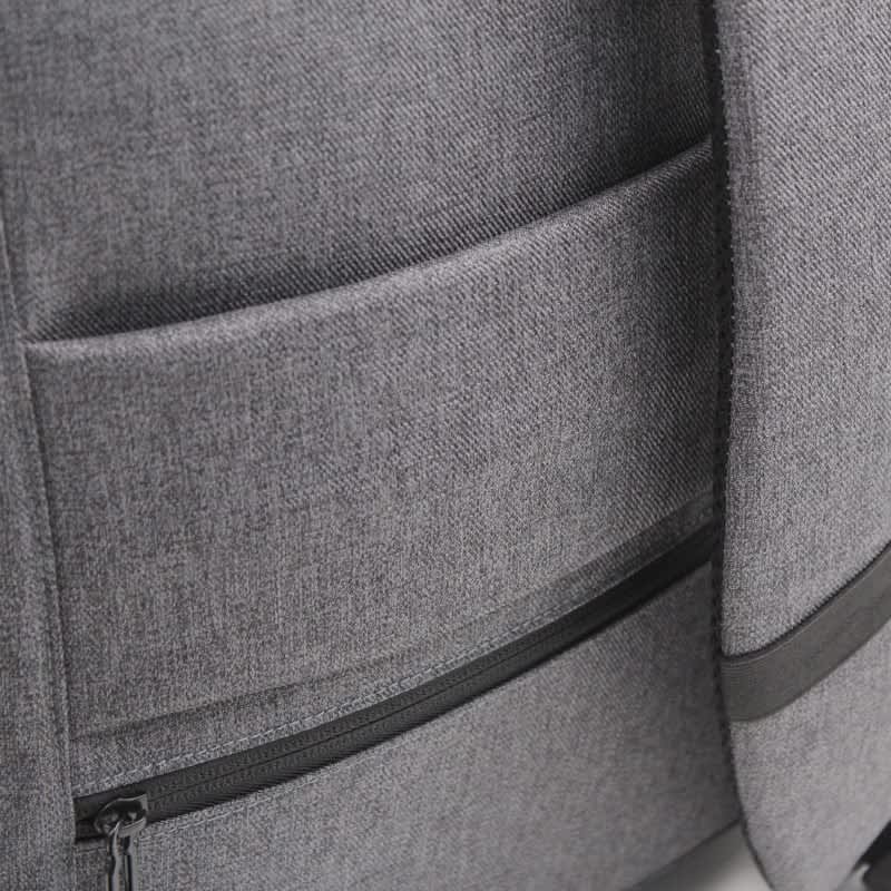 A grey backpack featuring multiple pockets and a sleek design, with a logo on the surface.