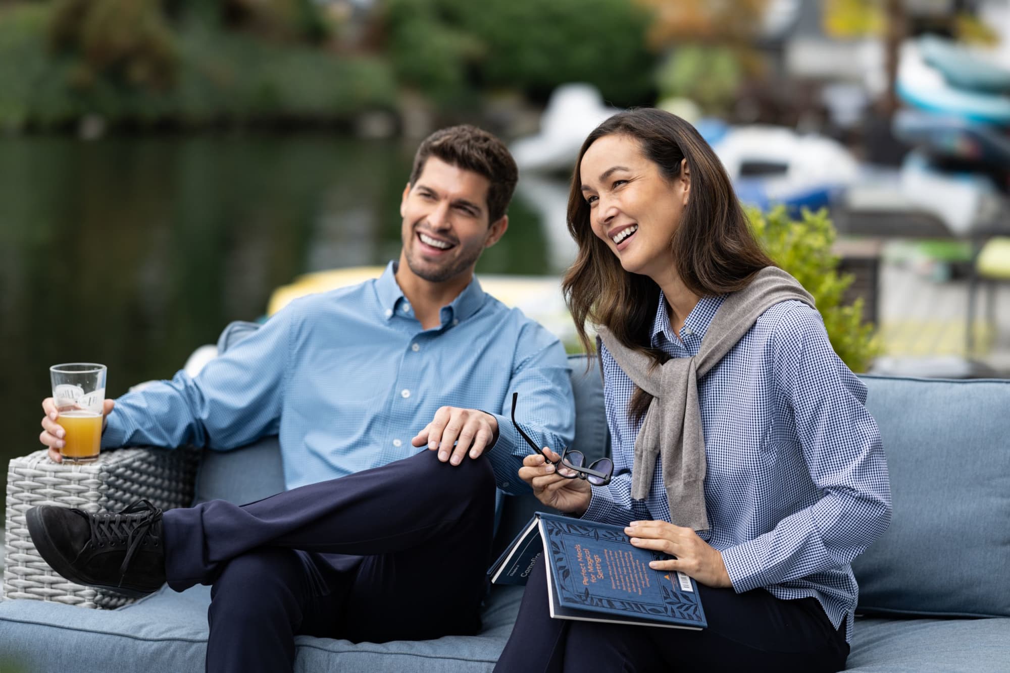 A men's gingham shirt in light blue and white, worn by a man and a woman outdoors, near a body of water.