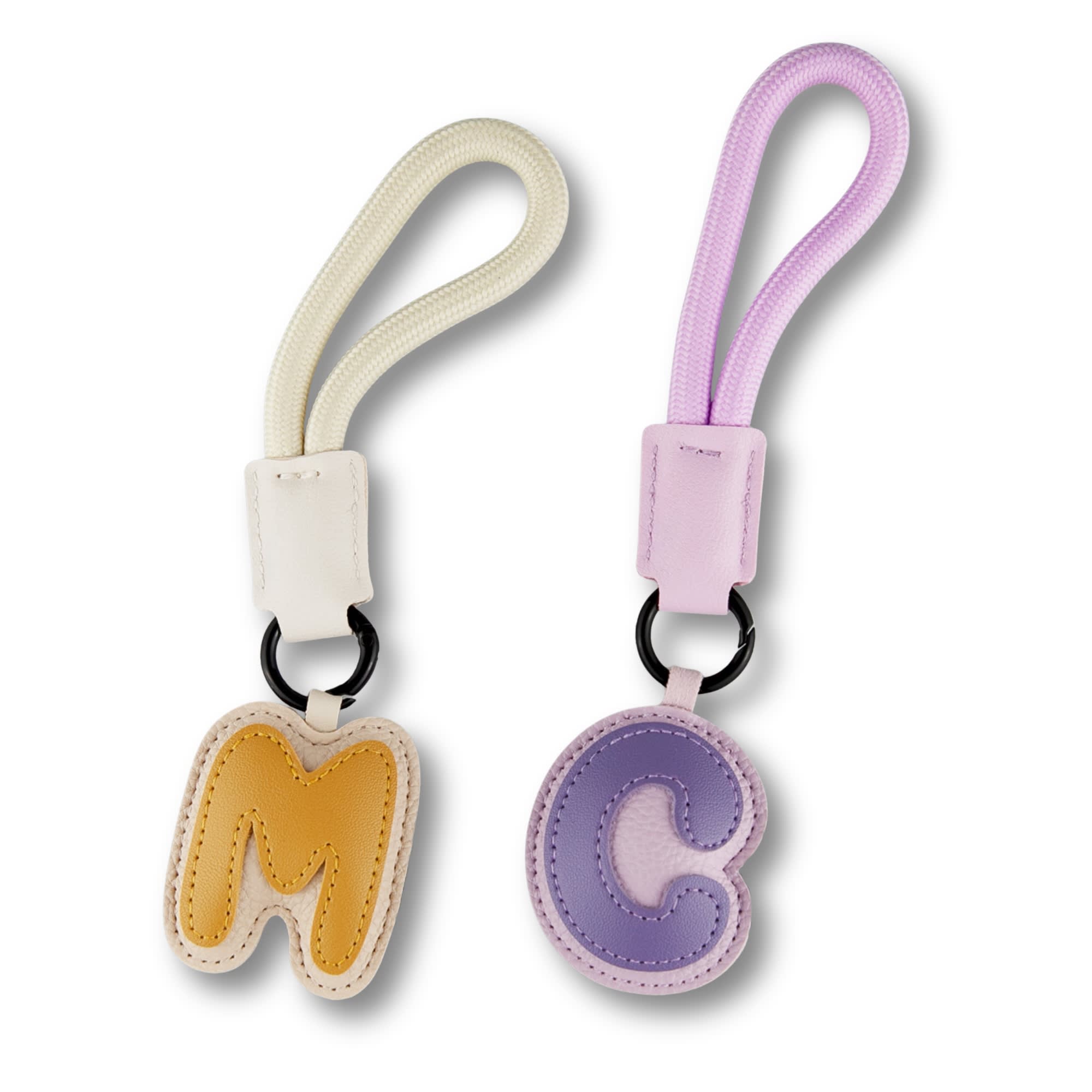Two bag charms in pastel colours: one yellow 'M' and one purple 'C', each with a detachable strap.