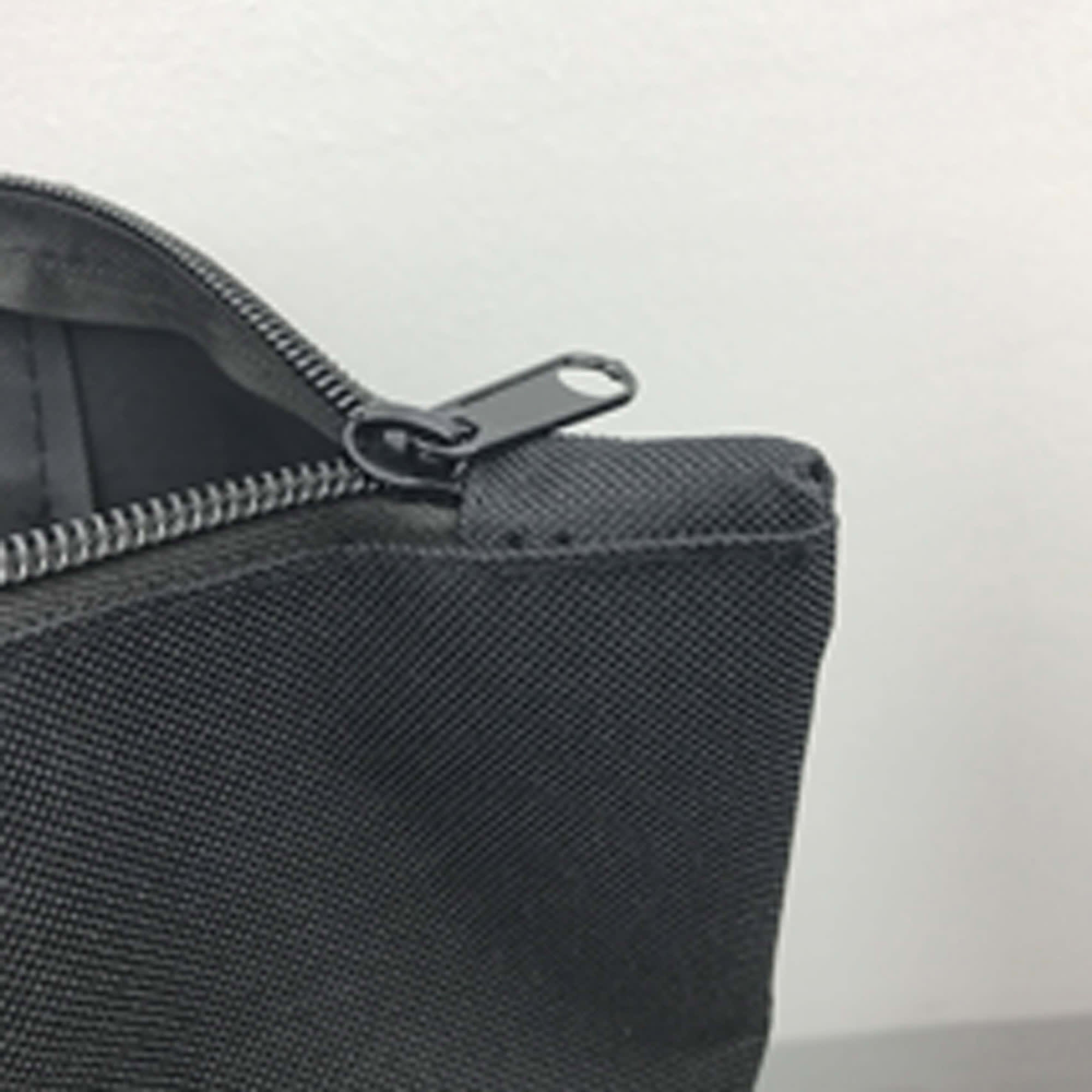 A grey nylon tote bag featuring a zipper closure and a metal zipper pull. It has a simple, minimalist design.