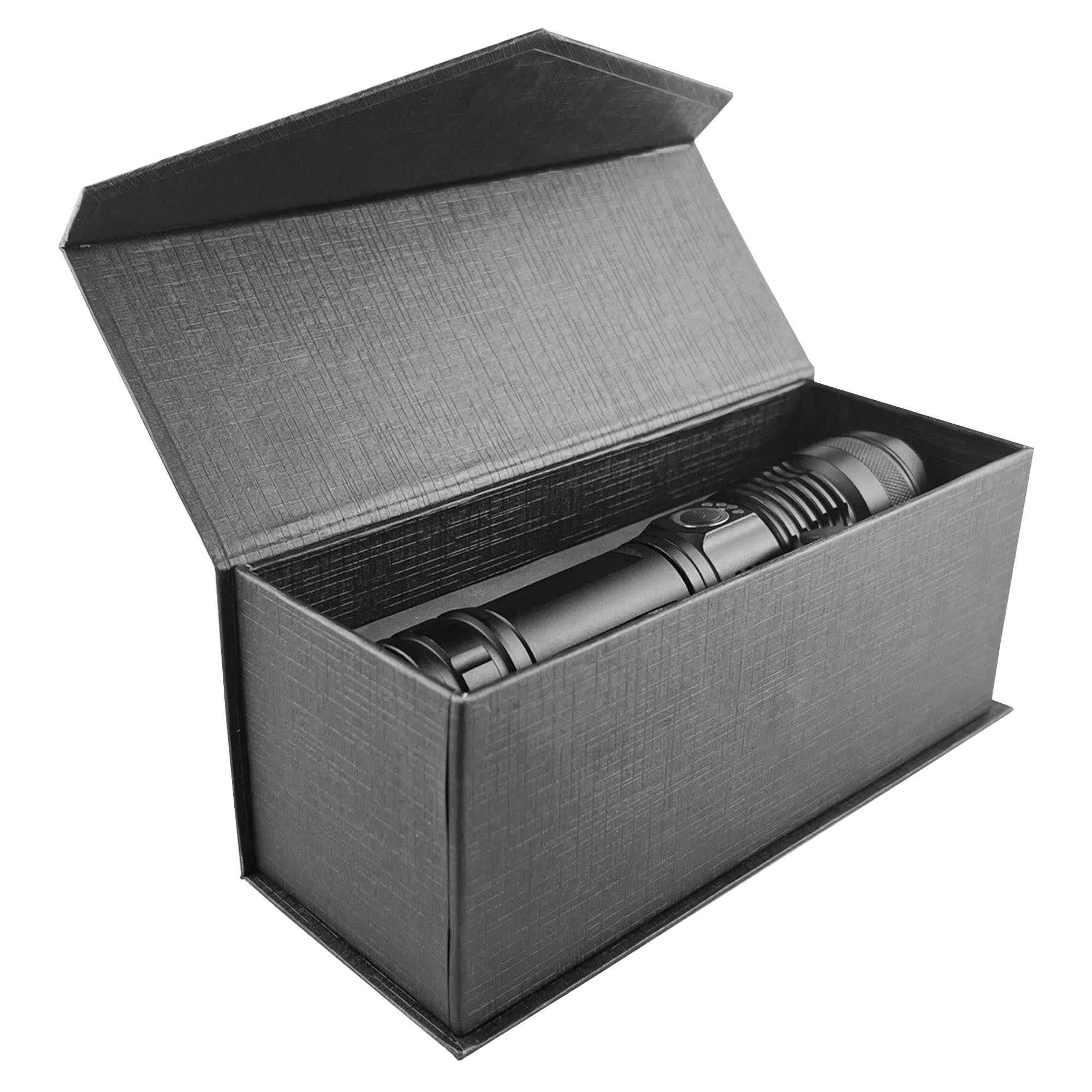 A black outdoor torch placed inside an open black box. The packaging has a textured finish.