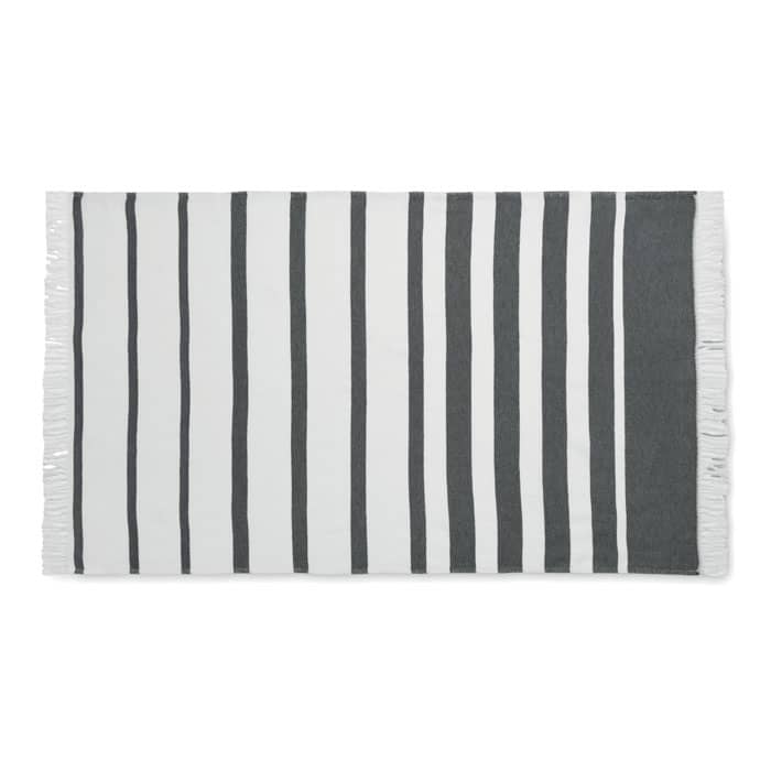 A striped beach towel featuring alternating dark grey and white stripes, with tasselled edges.