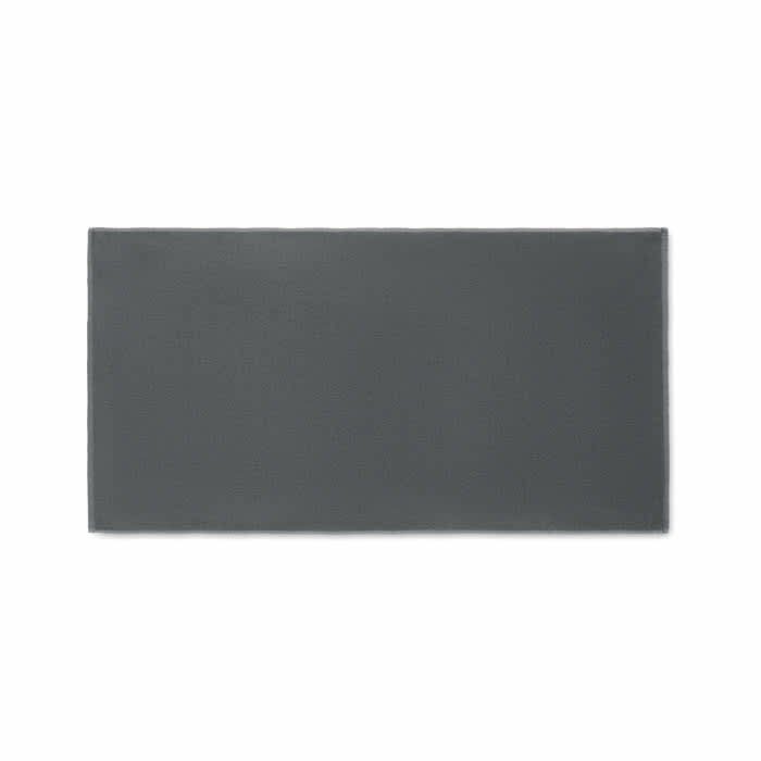 A rectangular grey mat with a smooth texture, featuring a simple design and a subtle branding logo.