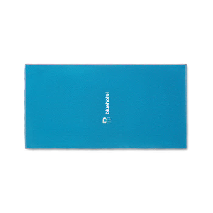 A rectangular blue yoga mat with a logo in the centre. The mat has a smooth texture and is designed for exercise.
