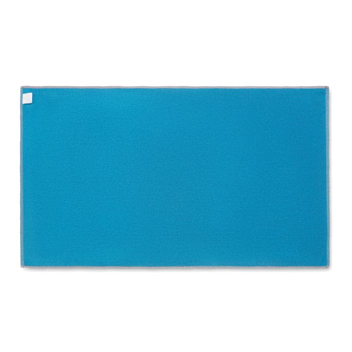 A bright blue promotional mat with a rectangular shape and a small label in one corner.