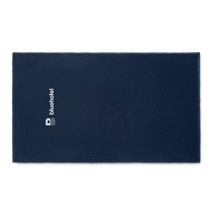 A navy blue promotional towel featuring a logo. The towel is rectangular and has a soft texture.
