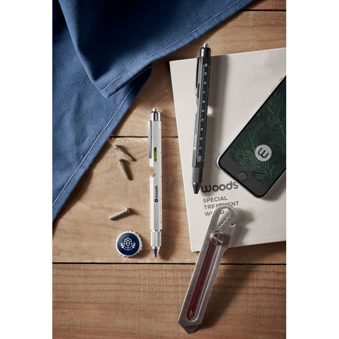 A collection of tools including a pen, screwdriver, and phone case on a wooden surface, with a blue cloth nearby.