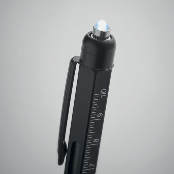 A black pen with a blue tip and measurement markings on the side. It has a clip for attaching to notebooks.